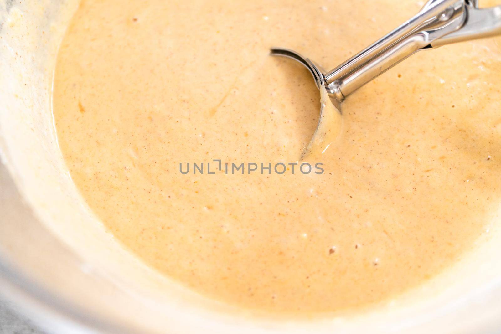 Pumpkin pancakes batter in a glass mixing bowl.