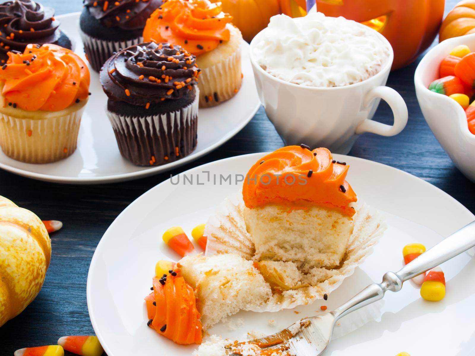 Eating Halloween cupcakes with orange and black icing.