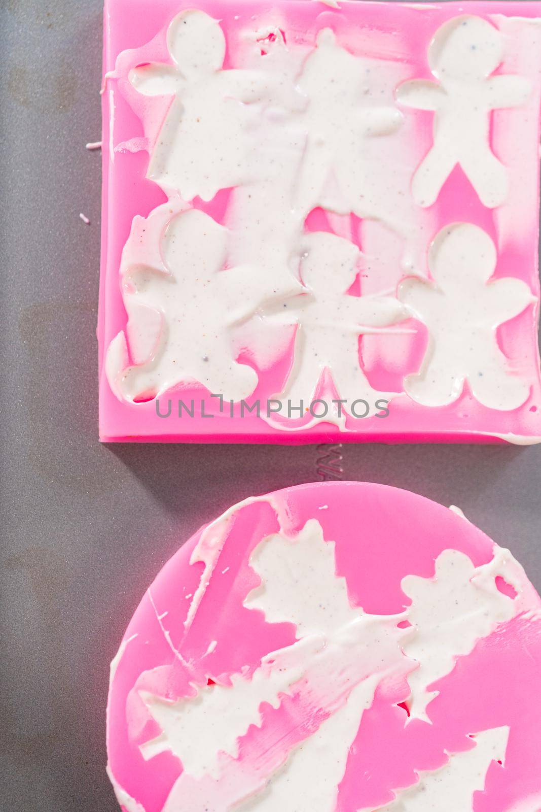 Filling silicone mold with white melted chocolate to make a chocolate gingerbread man.
