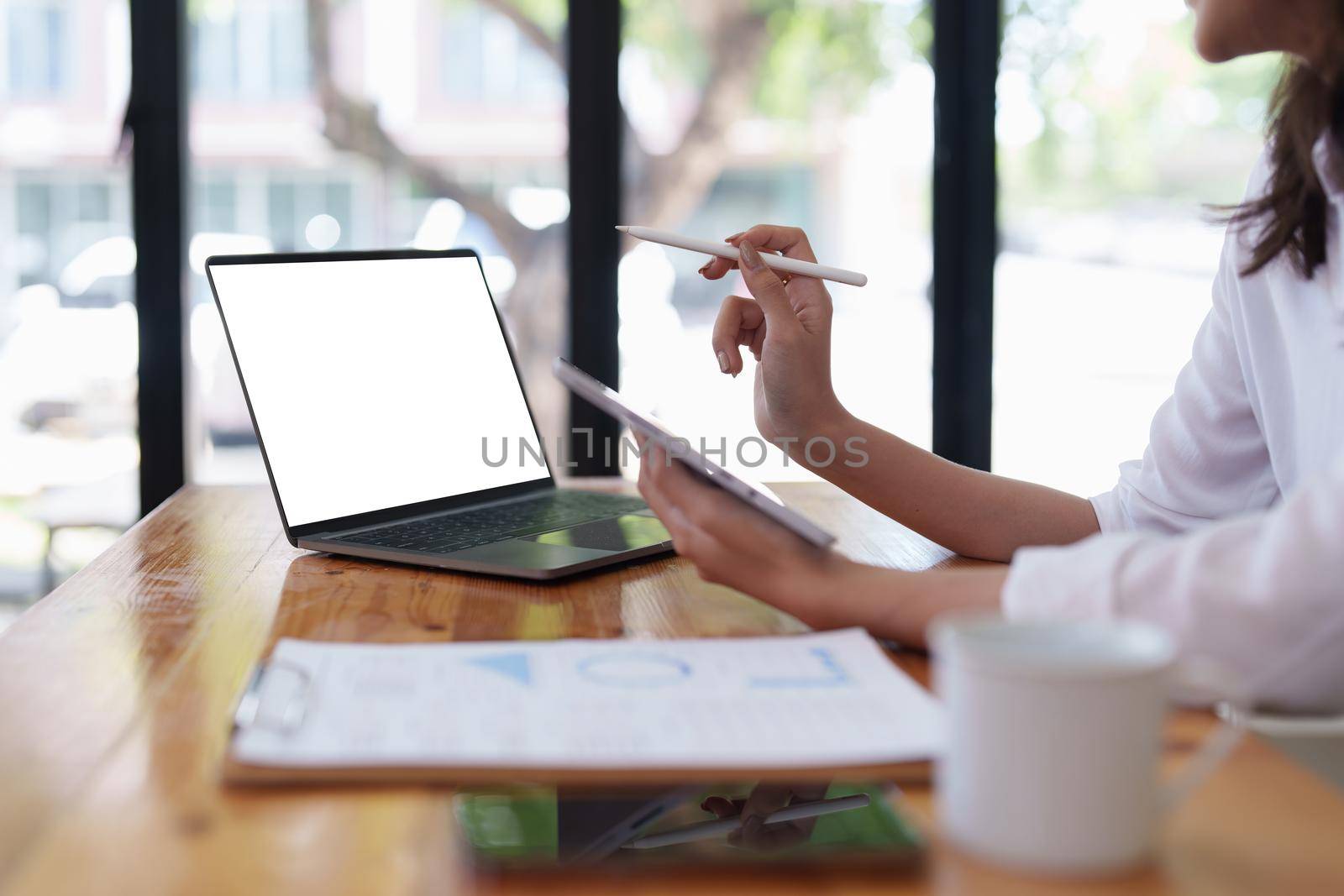 Asian entrepreneur making business plan while working on laptop with empty screen.