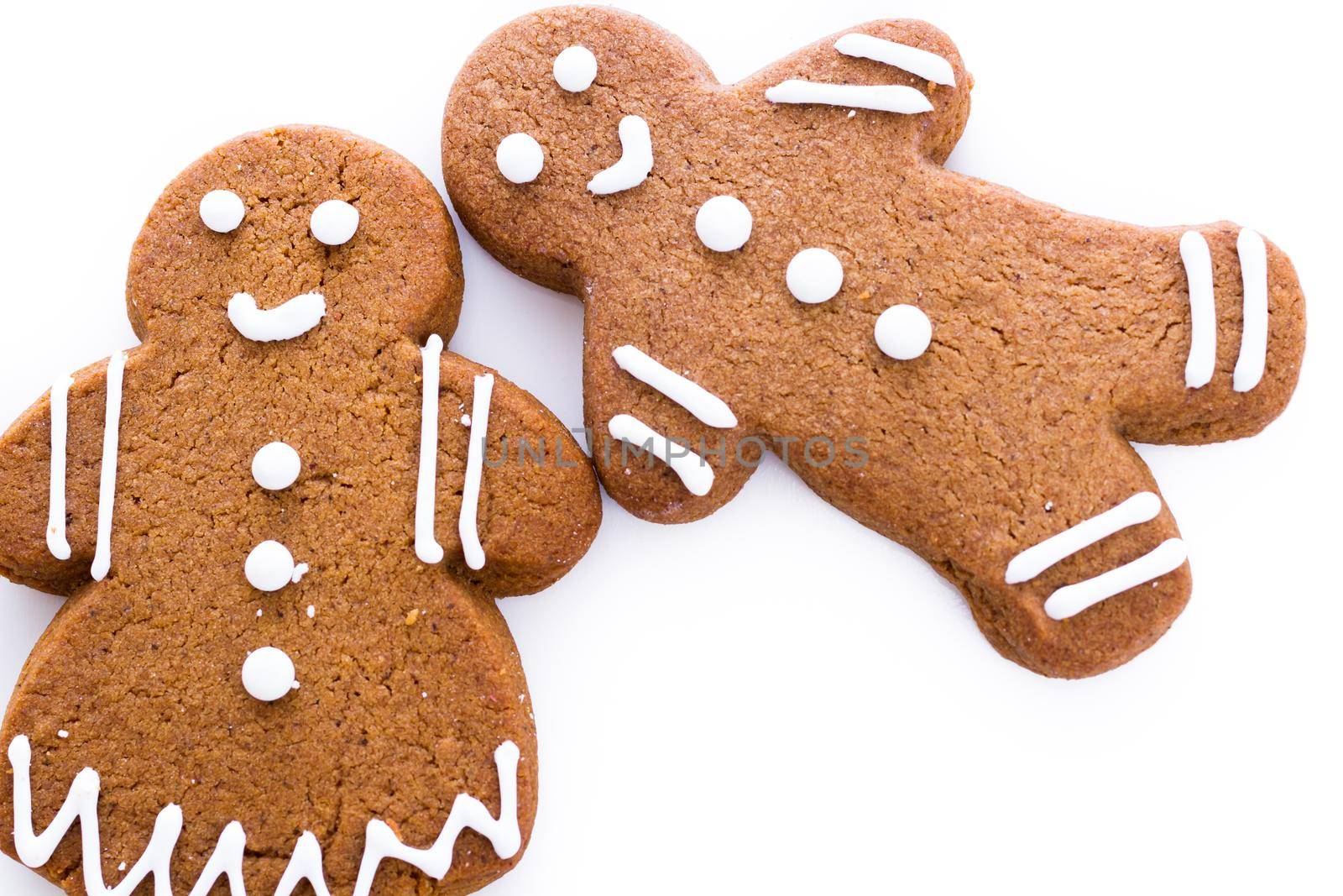 Homemade gingerbread cookies decorated with white icing on white background.