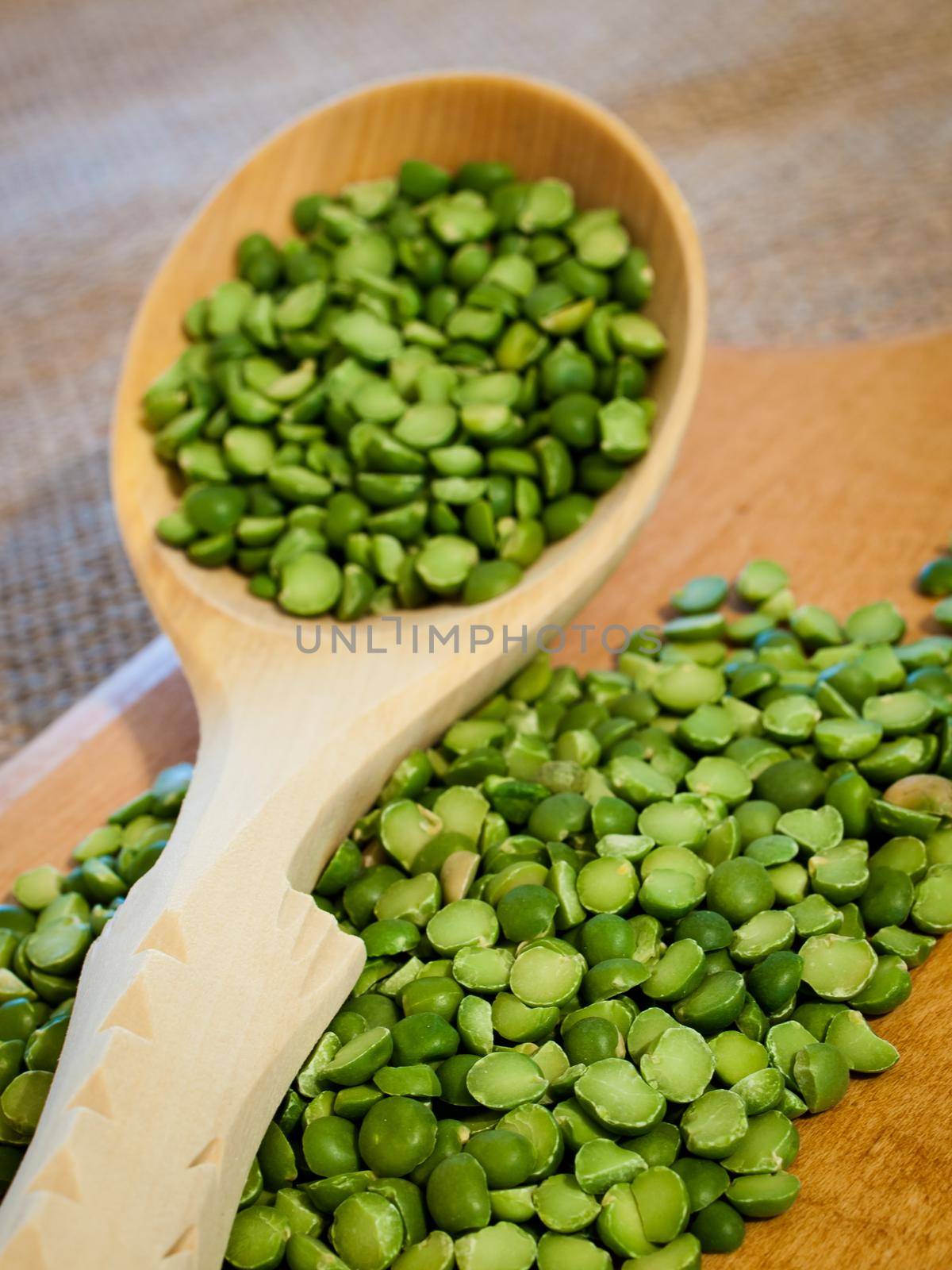 Green speat peas in wooden spoon.