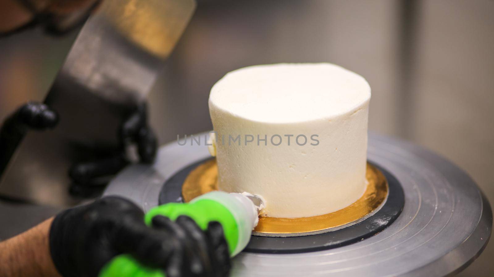 chef using using bag decorating a frosted icing cake