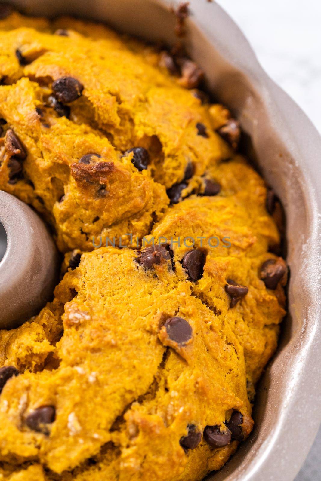 Cooling freshly baked chocolate pumpkin bundt cake on a kitchen counter.
