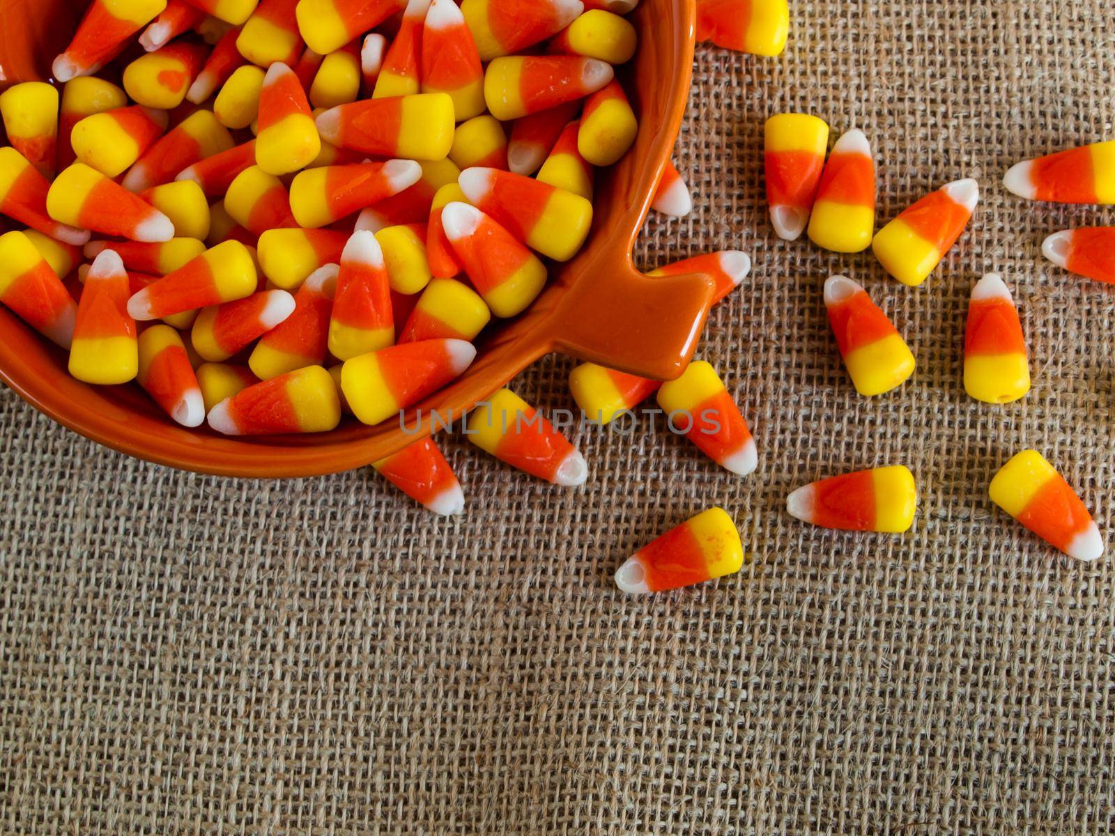 Traditional Halloween candies candy corn in orange bowl.