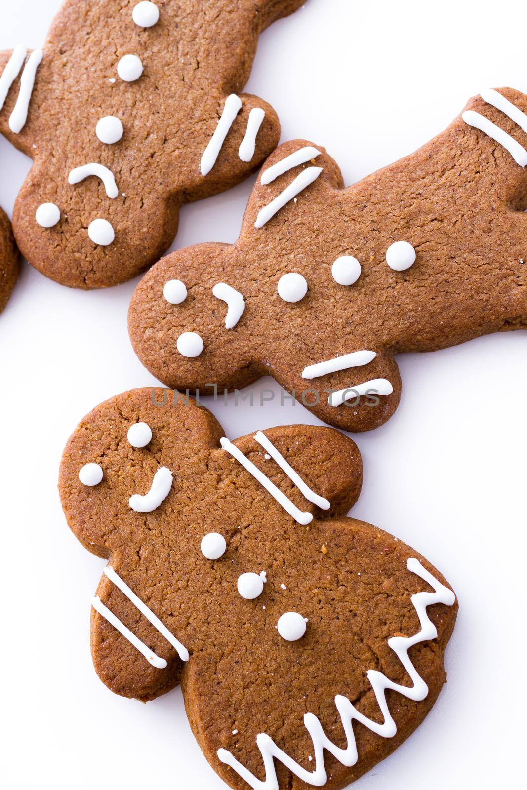 Homemade gingerbread cookies decorated with white icing on white background.