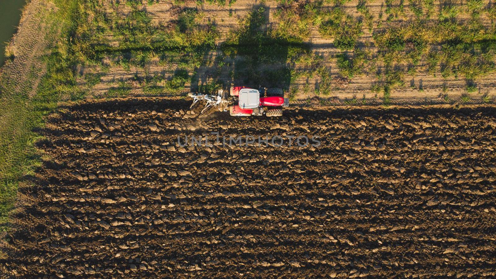 Aerial view with drone of tractor plowing the land in the countryside.