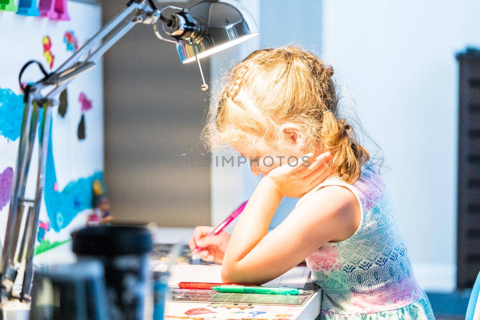 Little girl studying at home during the e-learning school.