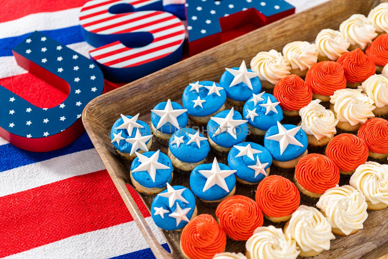 Arranging mini vanilla cupcakes in the shape of the American flag.