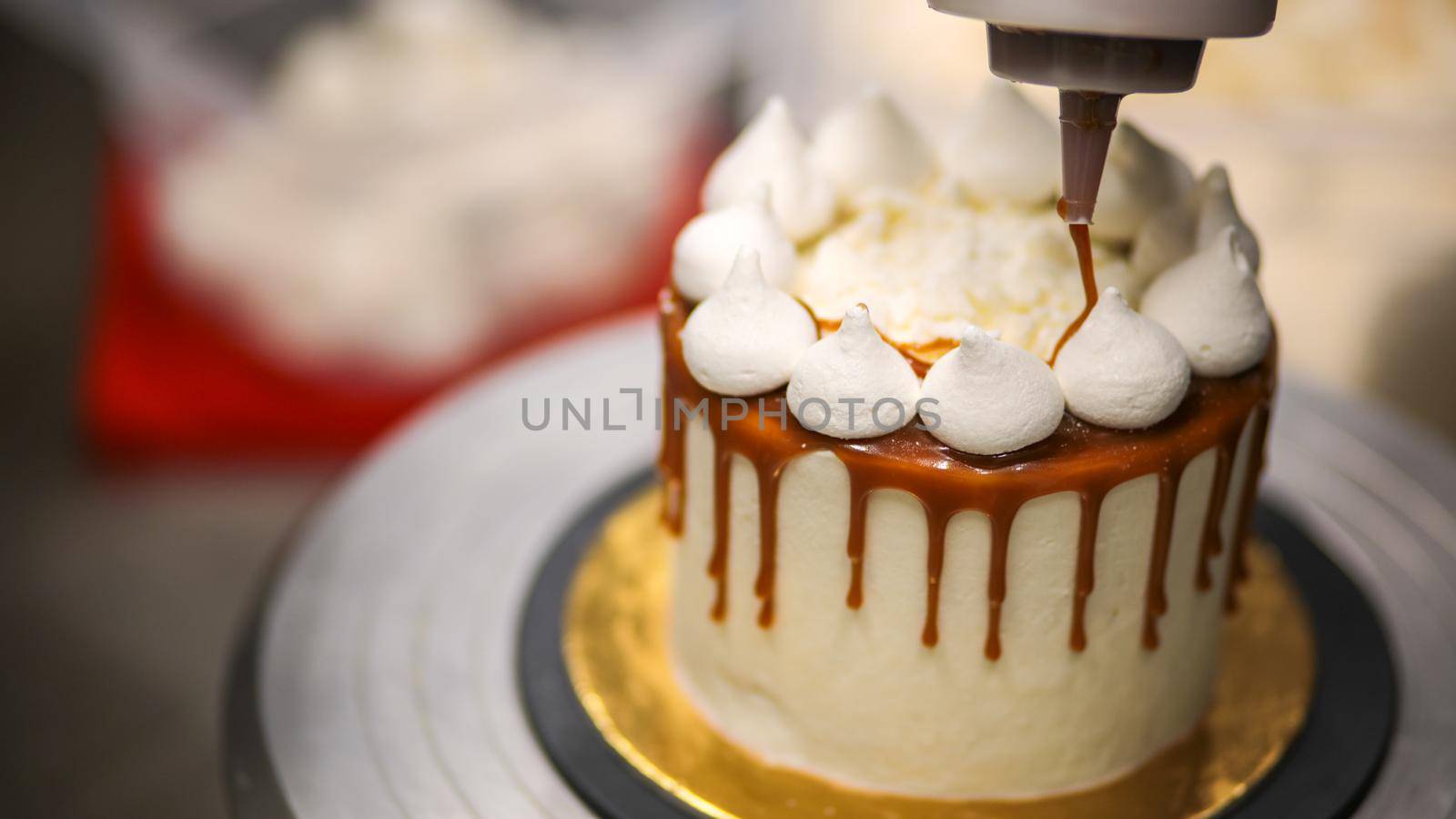 chef decorating the top of a frosted buttercream cake