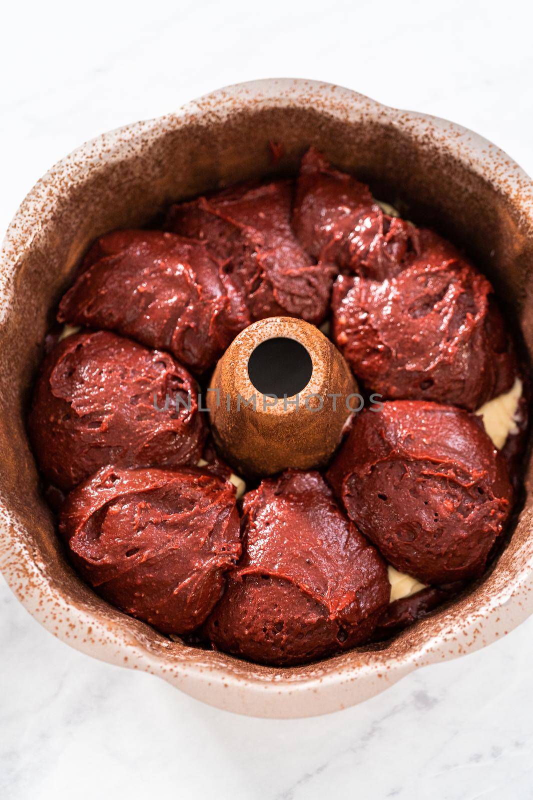Filling metal bundt cake pan with cake butter to bake red velvet bundt cake with cream cheese glaze