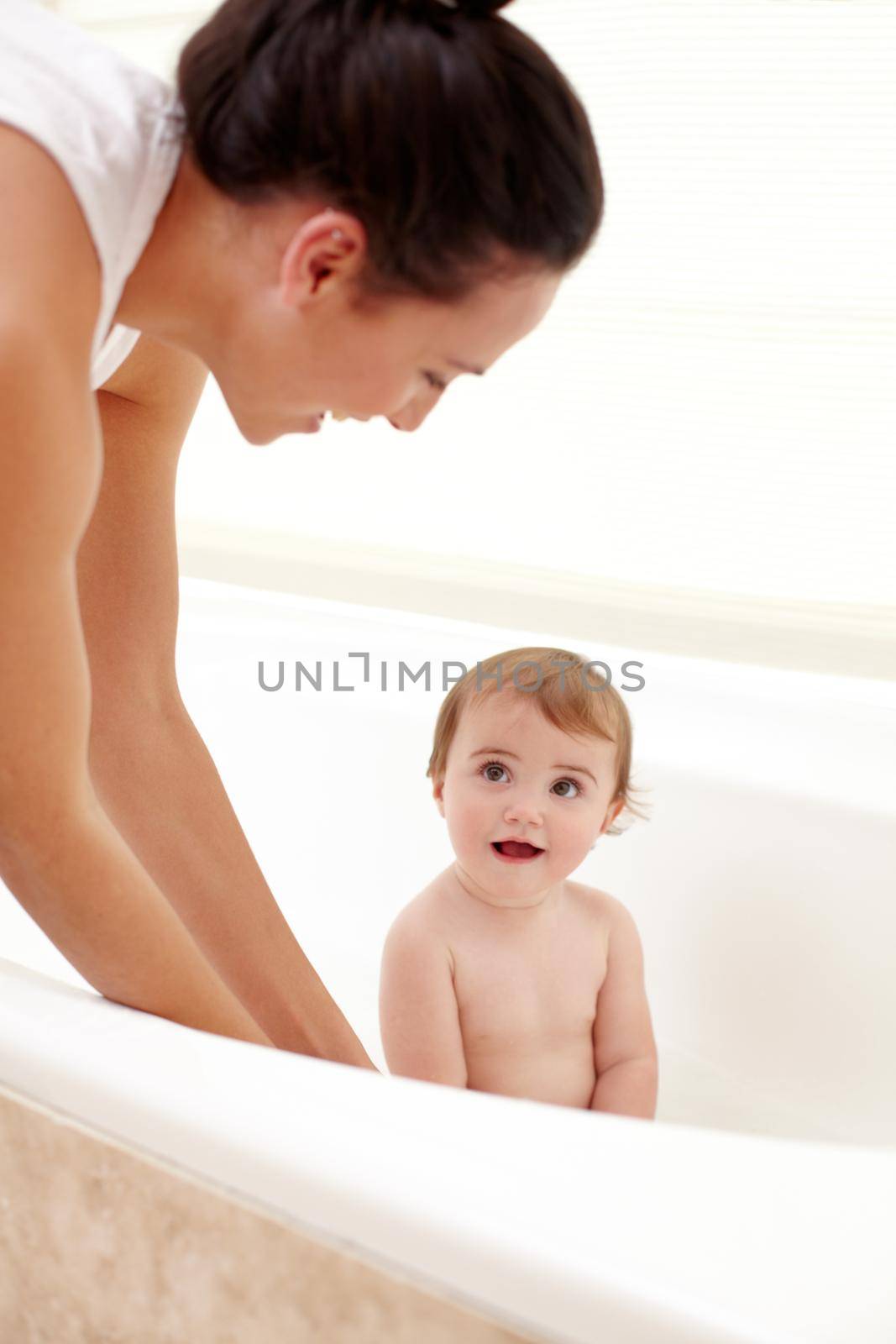 Her favorite time of day. A mother washing her adorable baby girl in the bath