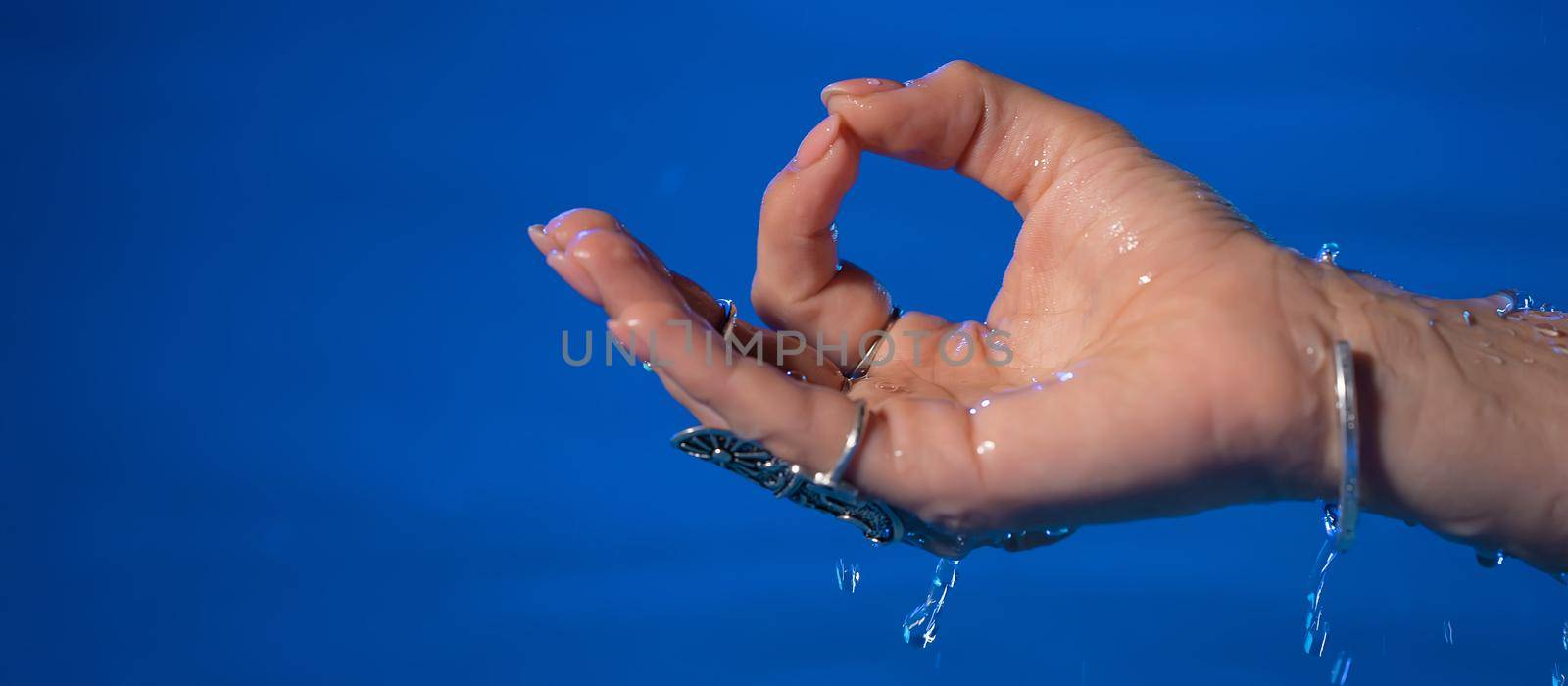 Hand of woman in mudra om in water, pool or river. Meditating in summer. Clean water . Girl calms down. Inner peace, yoga concept. High quality photo