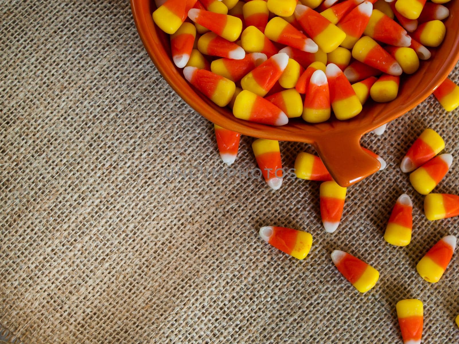 Traditional Halloween candies candy corn in orange bowl.