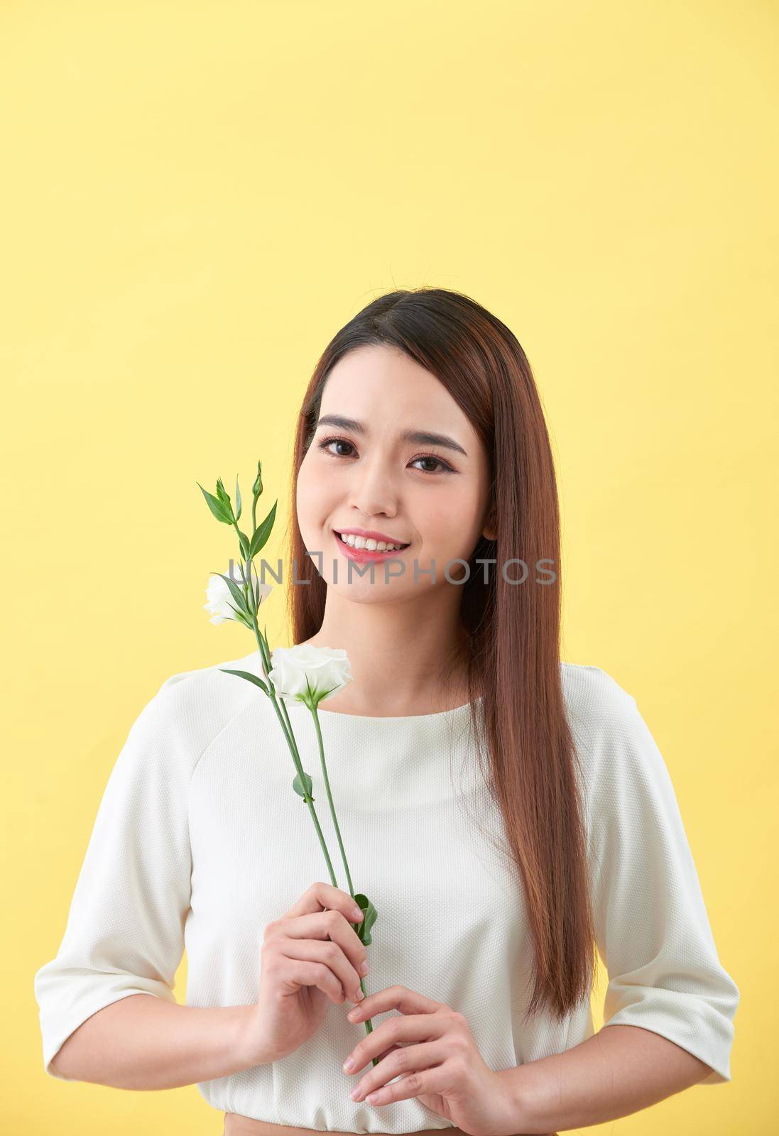Close up portrait of an attractive young woman holding flower by makidotvn