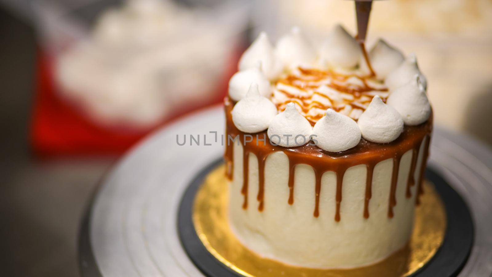 chef decorating the top of a frosted buttercream cake