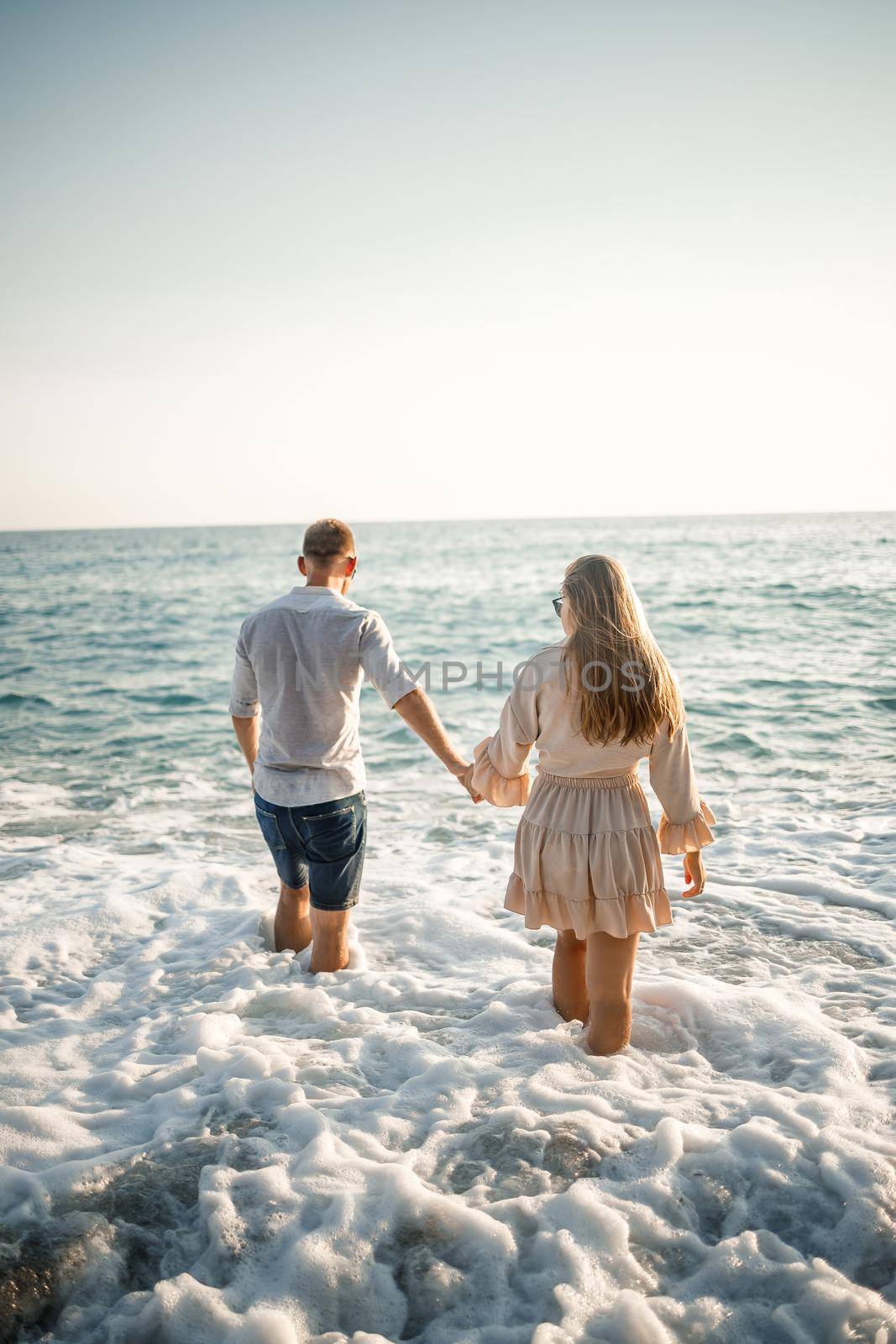 Happy couple by the sea. Honeymoon lovers. Man and woman on the island. Beautiful couple having fun on the seashore. Happy couple on vacation. Man and woman by the sea. by Dmitrytph