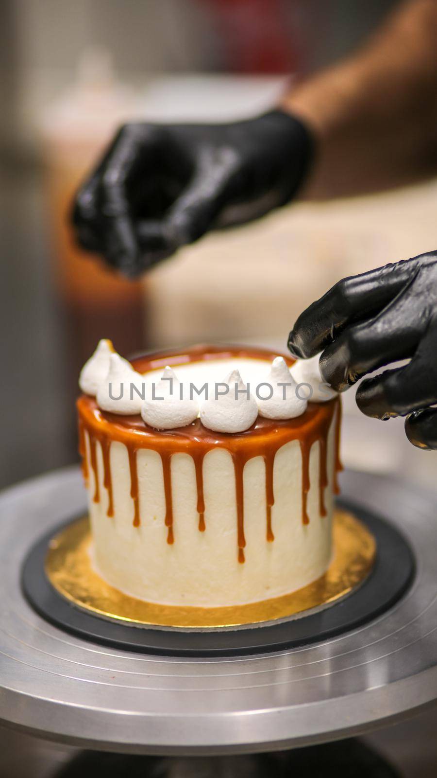 chef decorating the top of a frosted buttercream cake