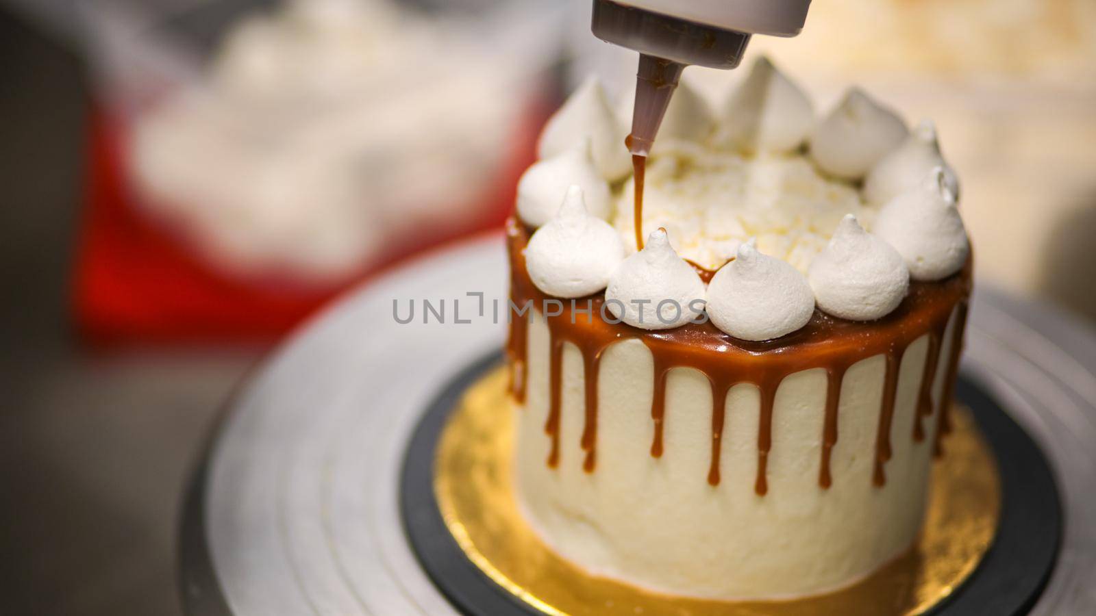 chef decorating the top of a frosted buttercream cake