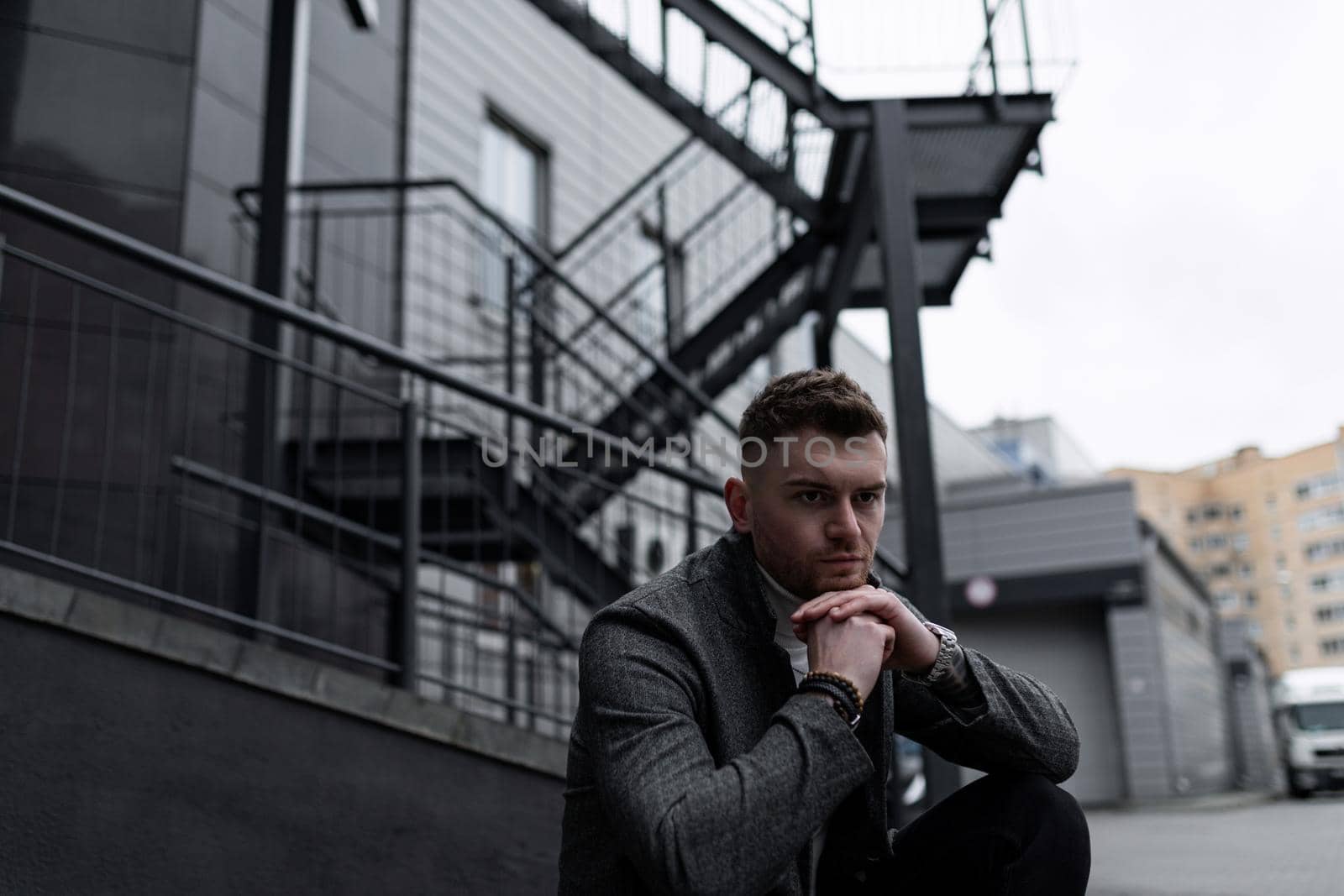 portrait of a brutal man against the background of a non-industrial building.