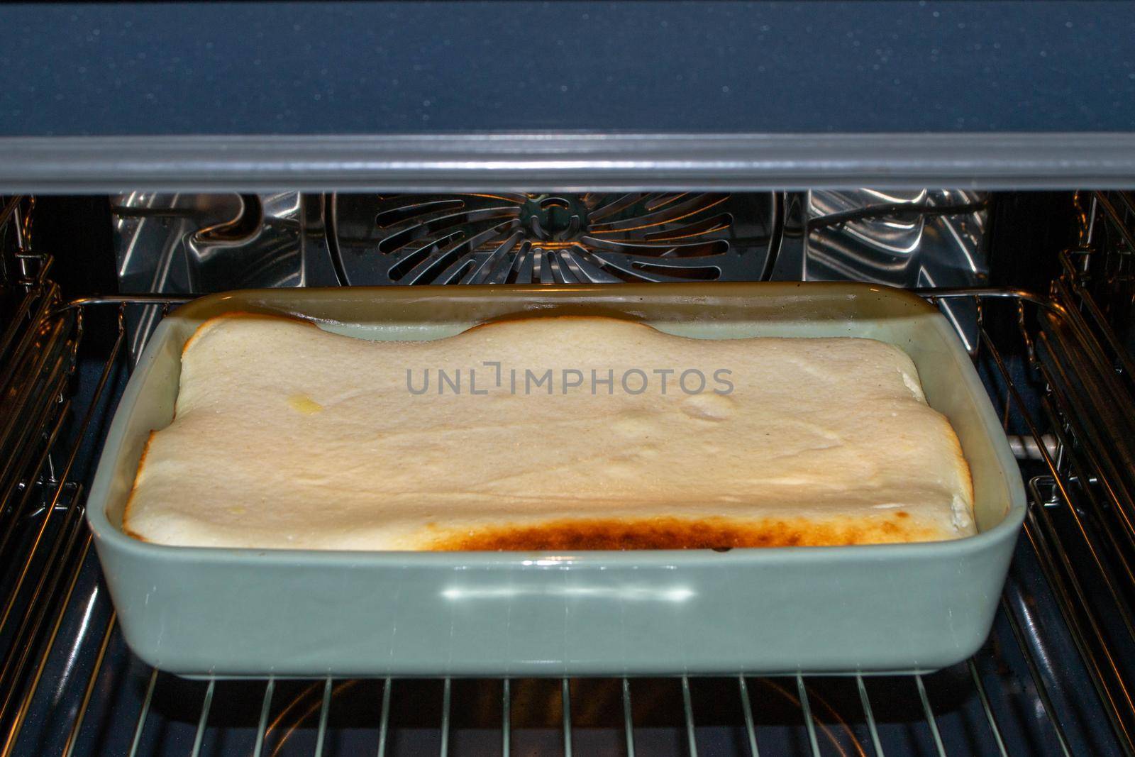 Cottage cheese casserole with raspberries and hazelnuts in a glass form is baked in the oven. Closeup. High quality photo