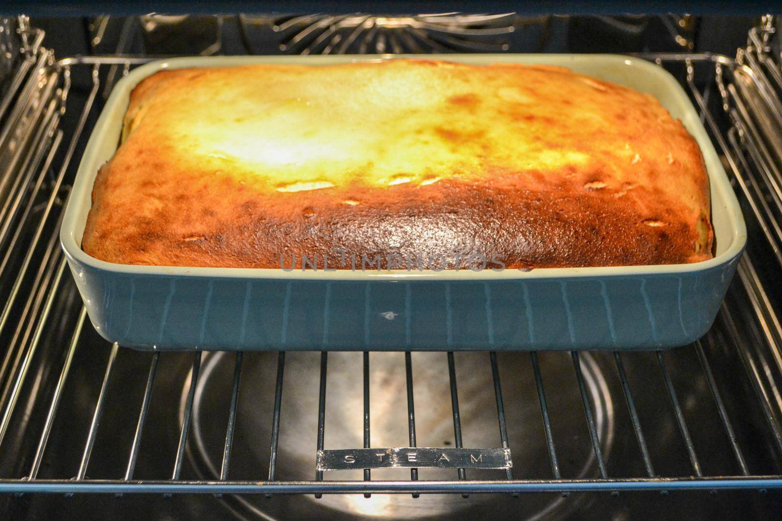 Cottage cheese casserole with raspberries and hazelnuts in a glass form is baked in the oven. Closeup. High quality photo