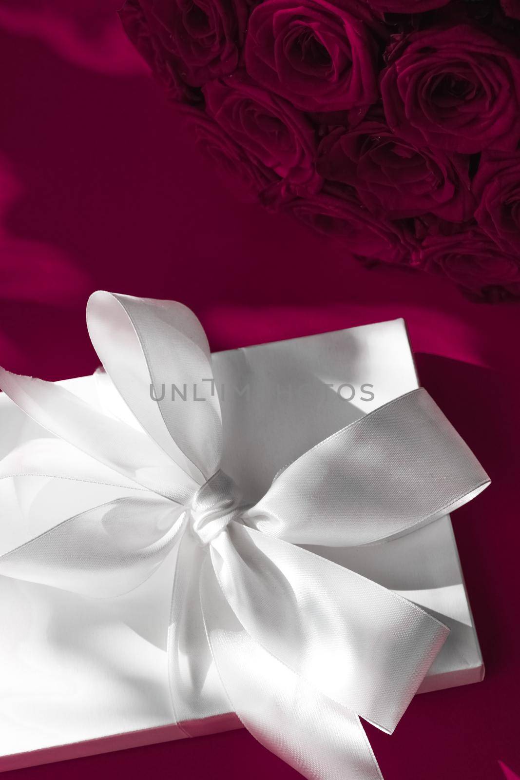 Happy holidays, luxe shopping and love gifts concept - Luxury holiday silk gift box and bouquet of roses on wine background, romantic surprise and flowers as birthday or Valentines Day present