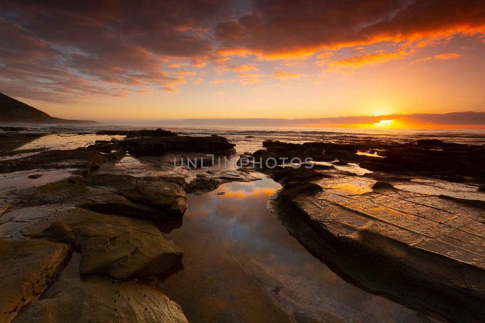 Beautiful sunrise over the ocean and  seashore with foreground rock pools by lovleah