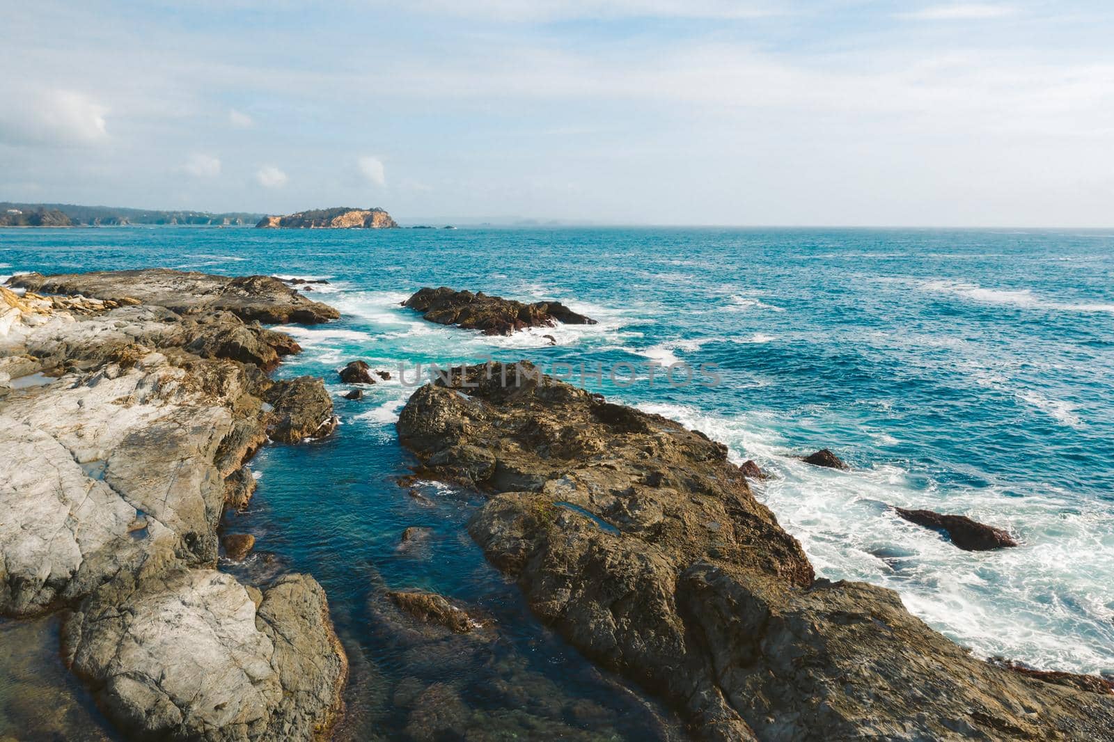 Coastal seascape with rocky fingers protruding the coast and views to the small islands