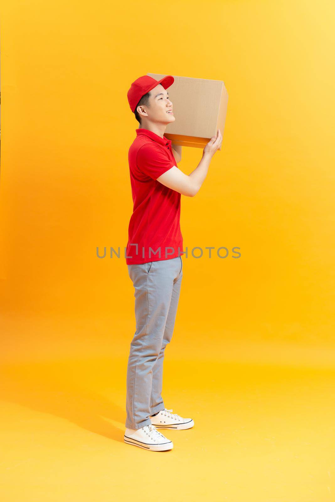 Delivery man with box on color background by makidotvn