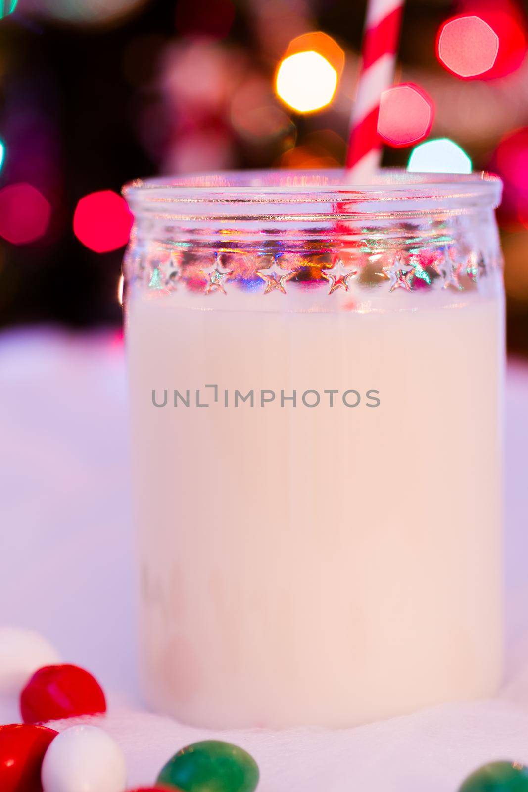 Glass of milk in a jar with a red straw.