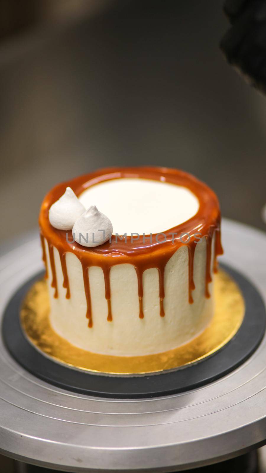 chef decorating the top of a frosted buttercream cake