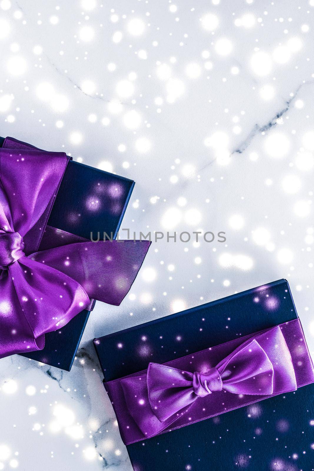 Branding, glamour and cold season concept - Winter holiday gift box with purple silk bow, snow glitter on marble background as Christmas and New Years presents for luxury beauty brand, flatlay design