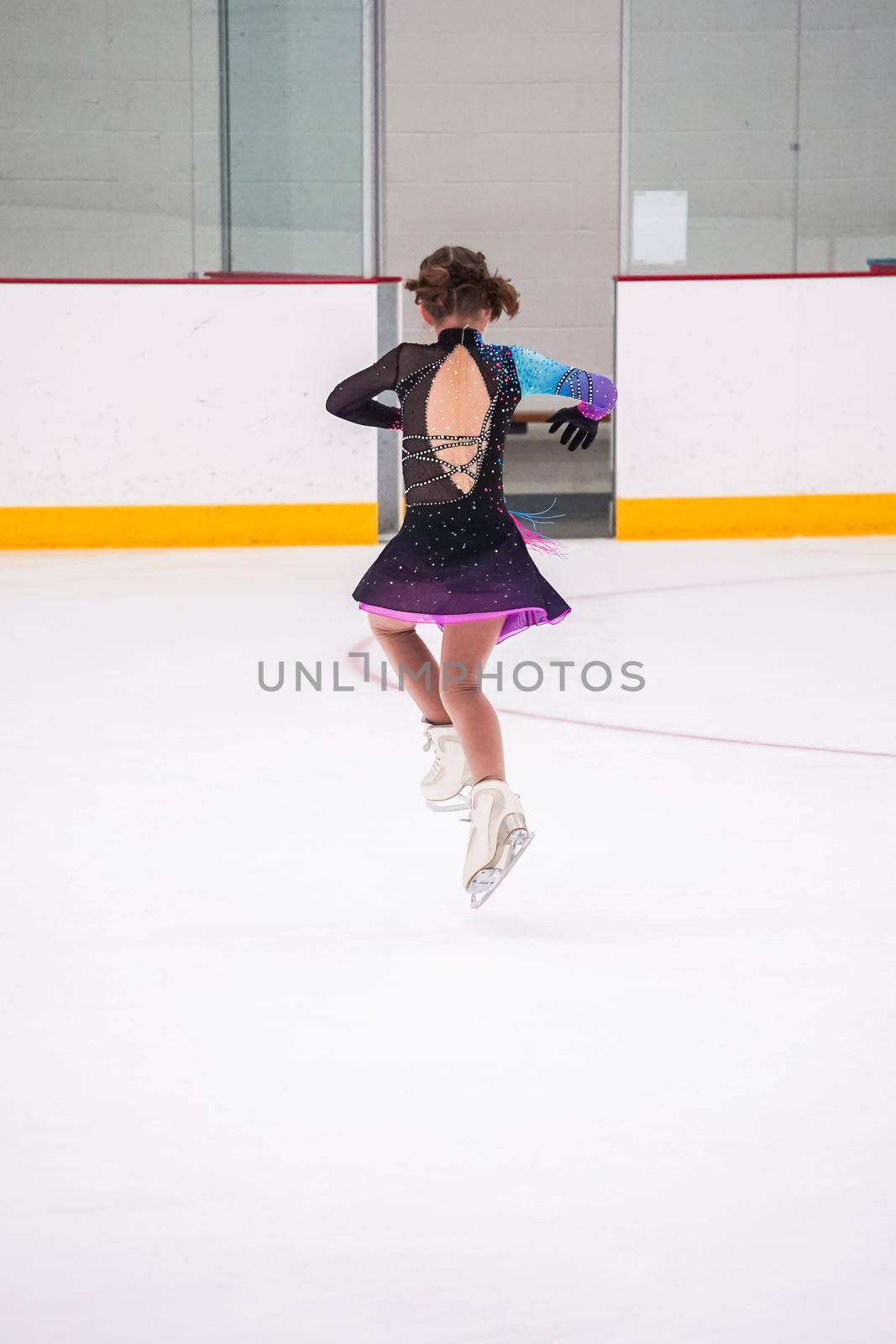 Little girl practicing before her figure skating competition at the indoor ice rink.