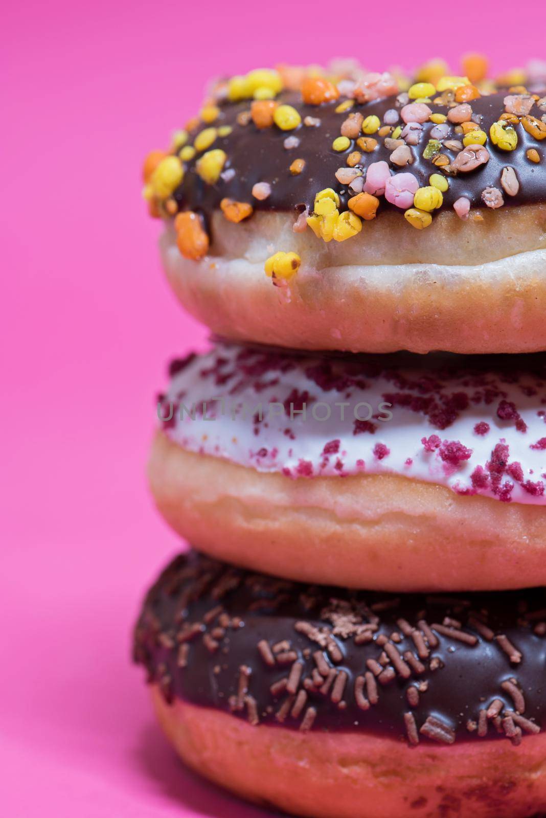 Macro shot of stack of donuts over pink by anytka