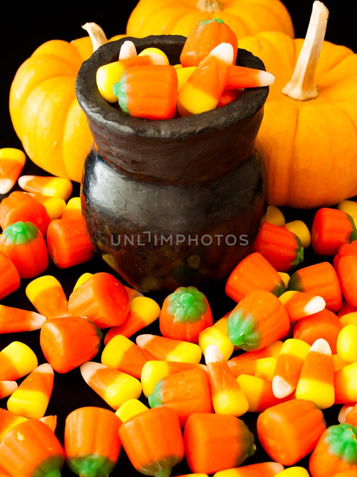 Halloween candies spilled on black background.