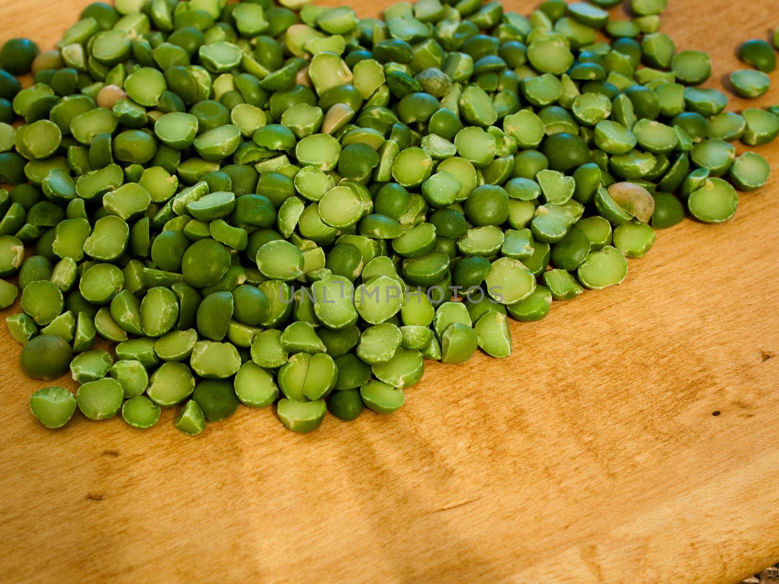Green speat peas on wooden cutting board.