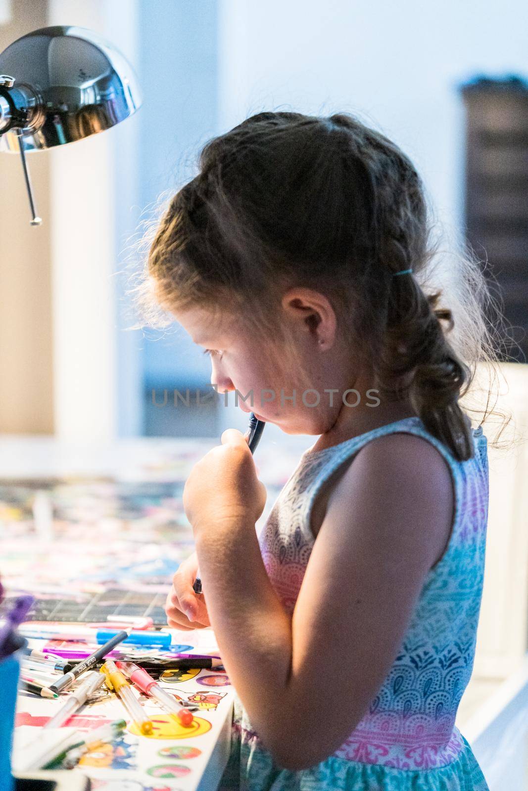 Little girl studying at home during the e-learning school.