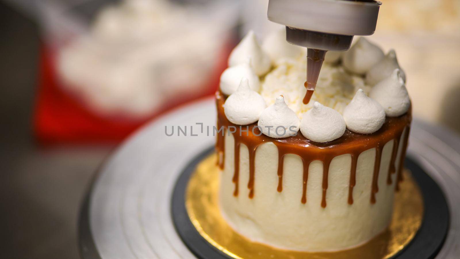 chef decorating the top of a frosted buttercream cake