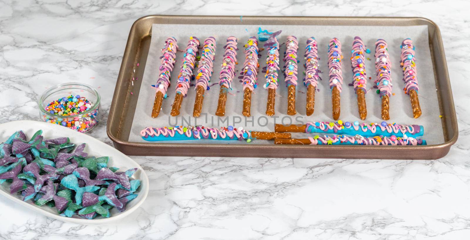 Mermaid chocolate pretzel rods drizzled with pink and purple chocolate and covered with sprinkles.