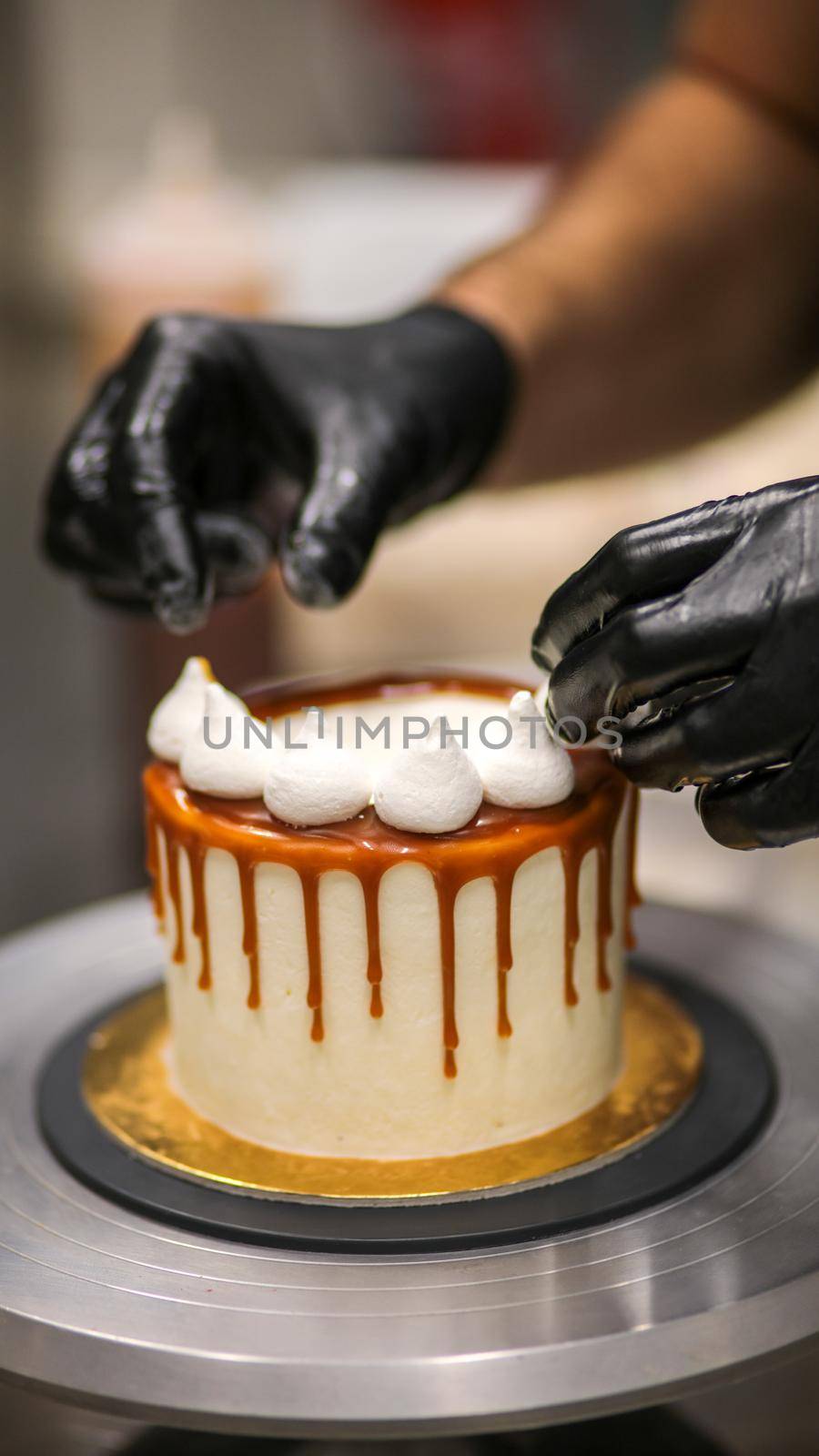 chef decorating the top of a frosted buttercream cake