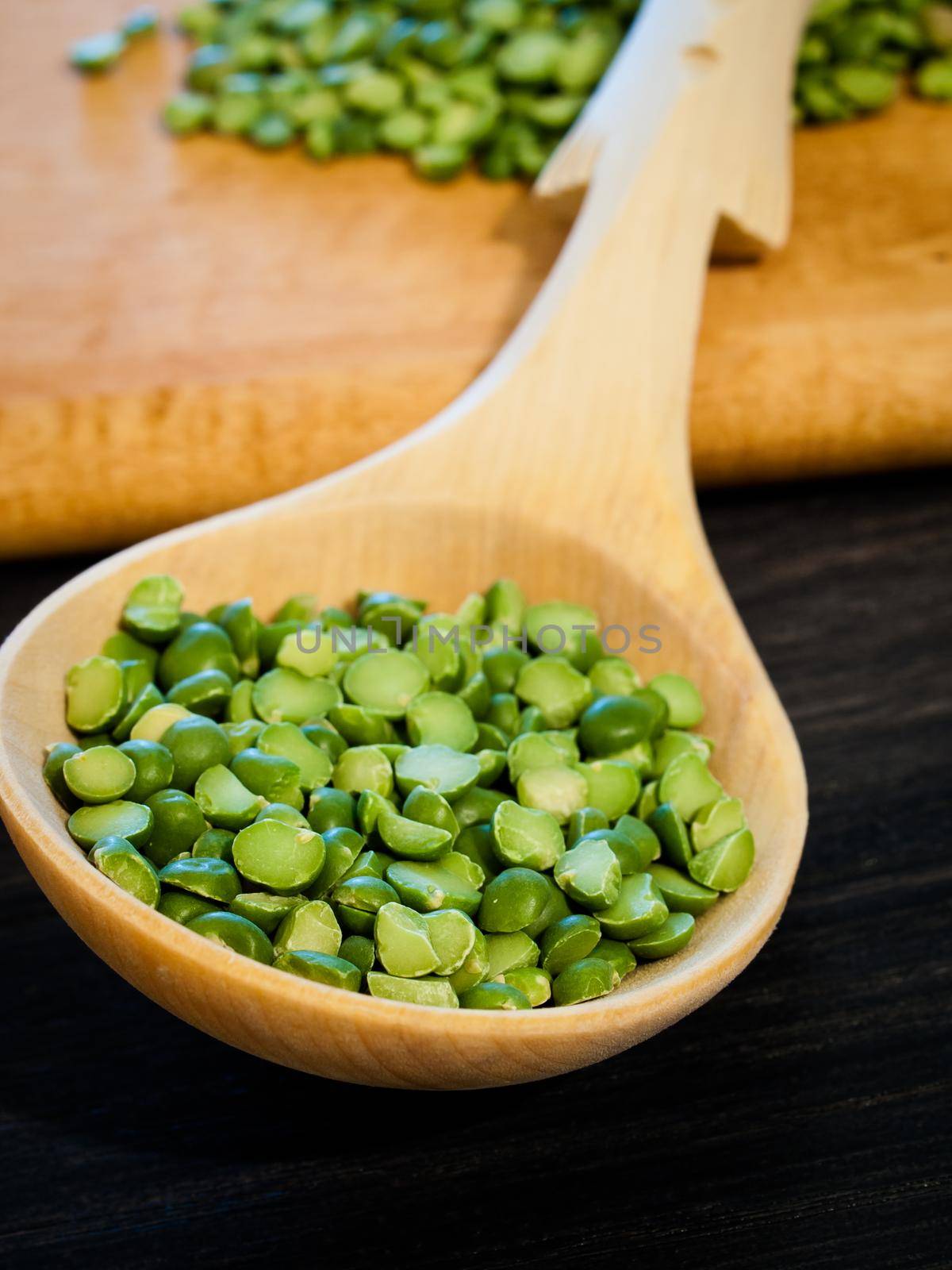 Green speat peas in wooden spoon.