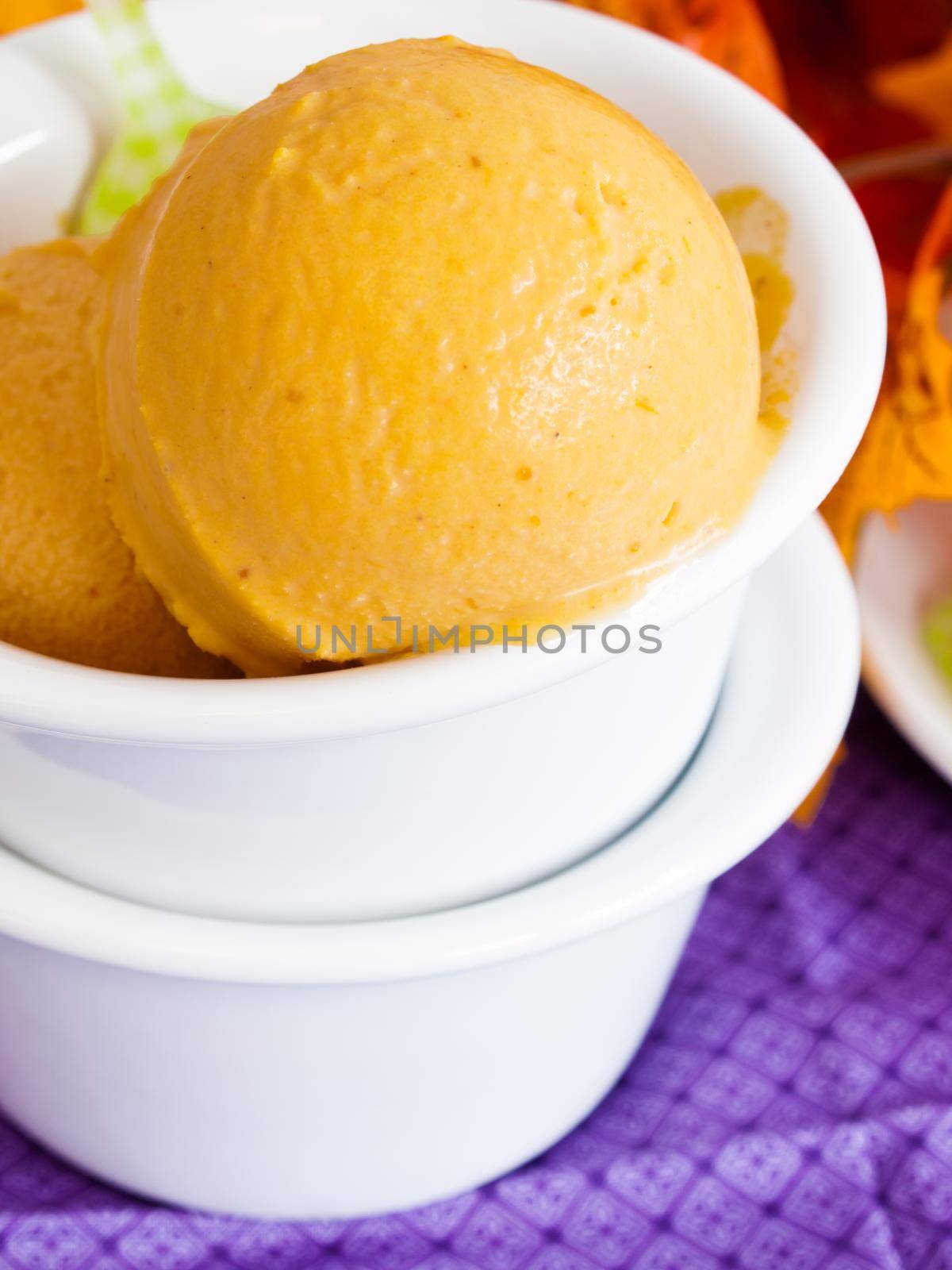 Scoop of gourmet pumpkin gelato in white bowl.