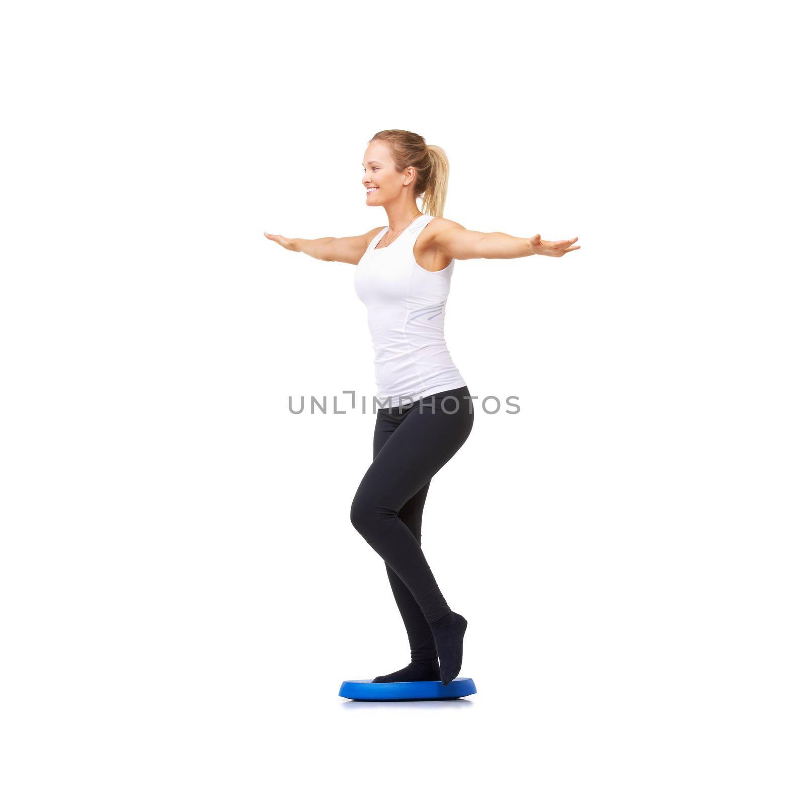 Keeping her footing steady. Full length studio shot of an attractive woman doing balance exercises isolated on white. by YuriArcurs