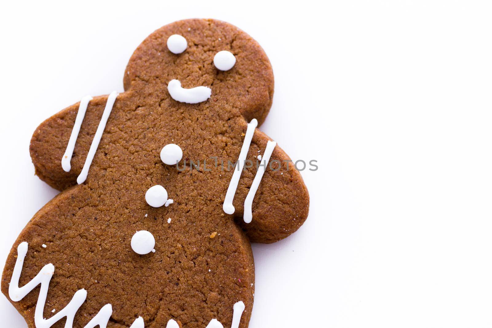 Homemade gingerbread cookies decorated with white icing on white background.