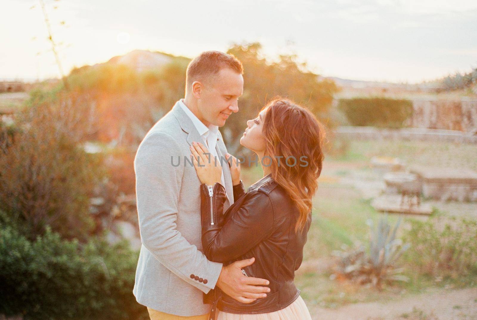 Bride put her hands on the chest of groom, hugging her waist. High quality photo