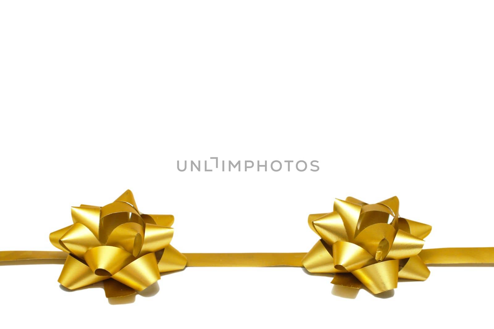 Two golden gift bows with a ribbon on a white background with copy space. isolated object. Universal template for postcards, posters, banners.