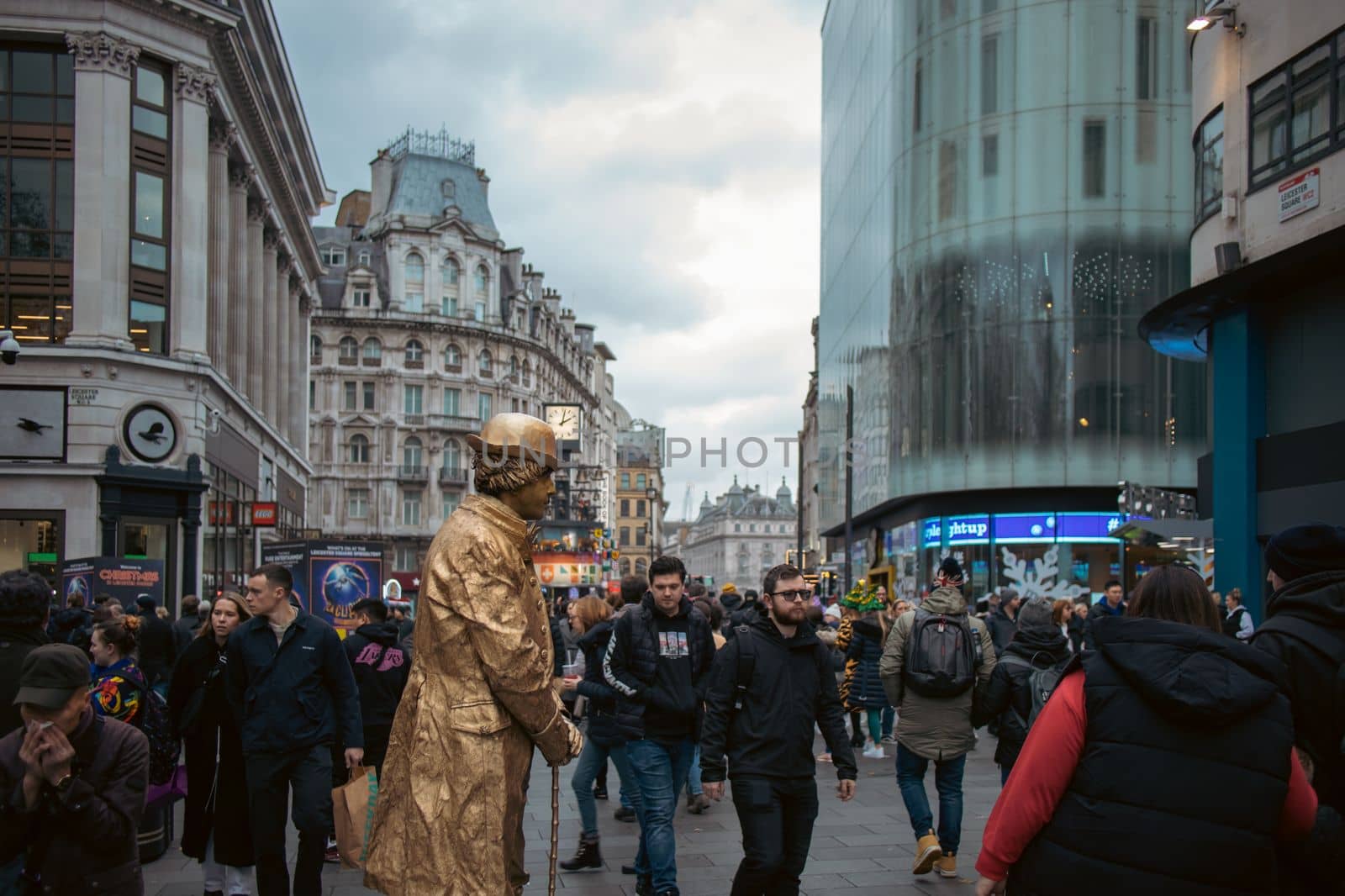 London, December 3rd 2022 - Living human statue street artist performing at Leicester Square Christmas Market with passers by