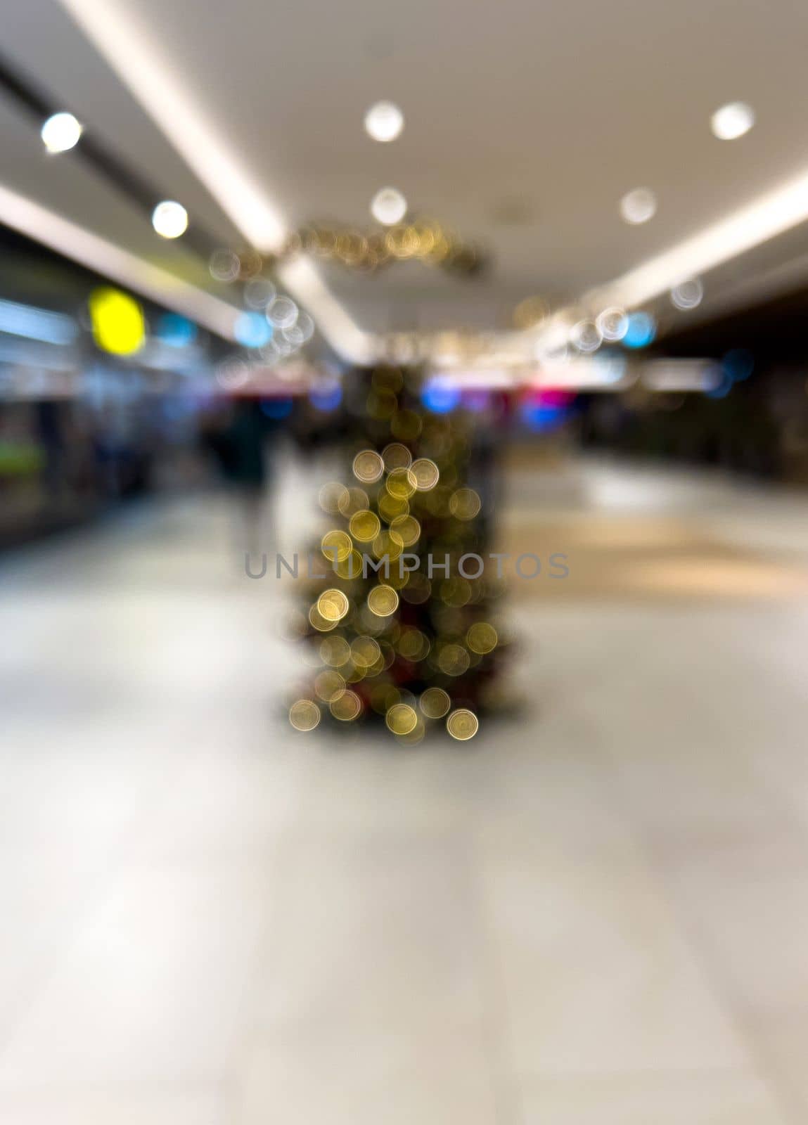 blurred decorated christmas tree in shopping mall background by Chechotkin