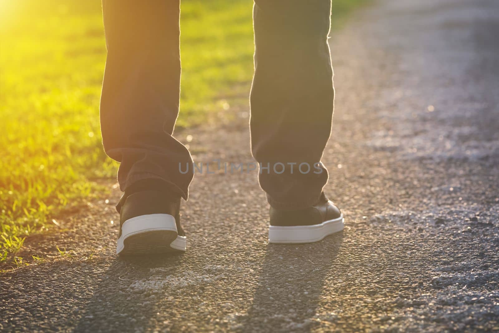 Man walking outdoors in the park at sunset. Man on his way to a new better life. The way forward. New start, new life and freedom concept. High quality photo